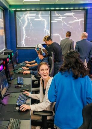 Two students smile and chat while playing video games in the Nor’easter ESport Room